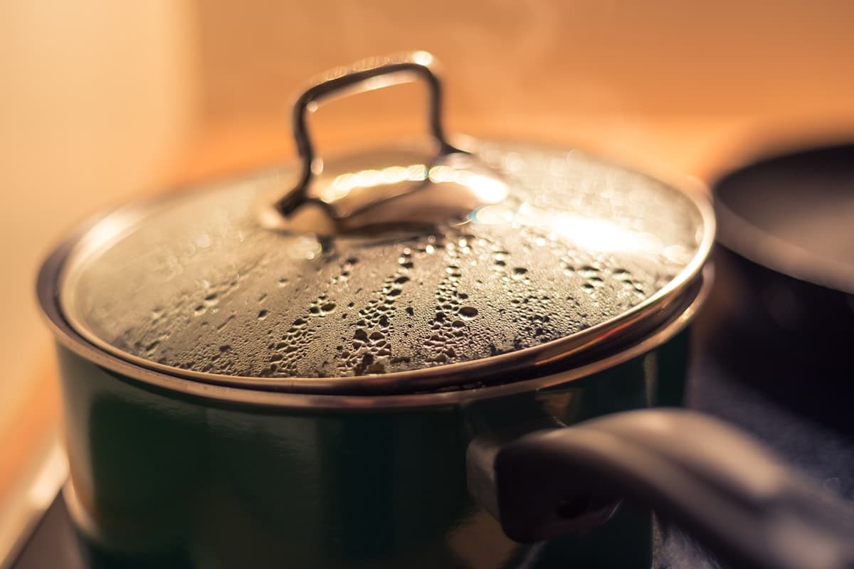 A steaming pot of water cooking on a stove