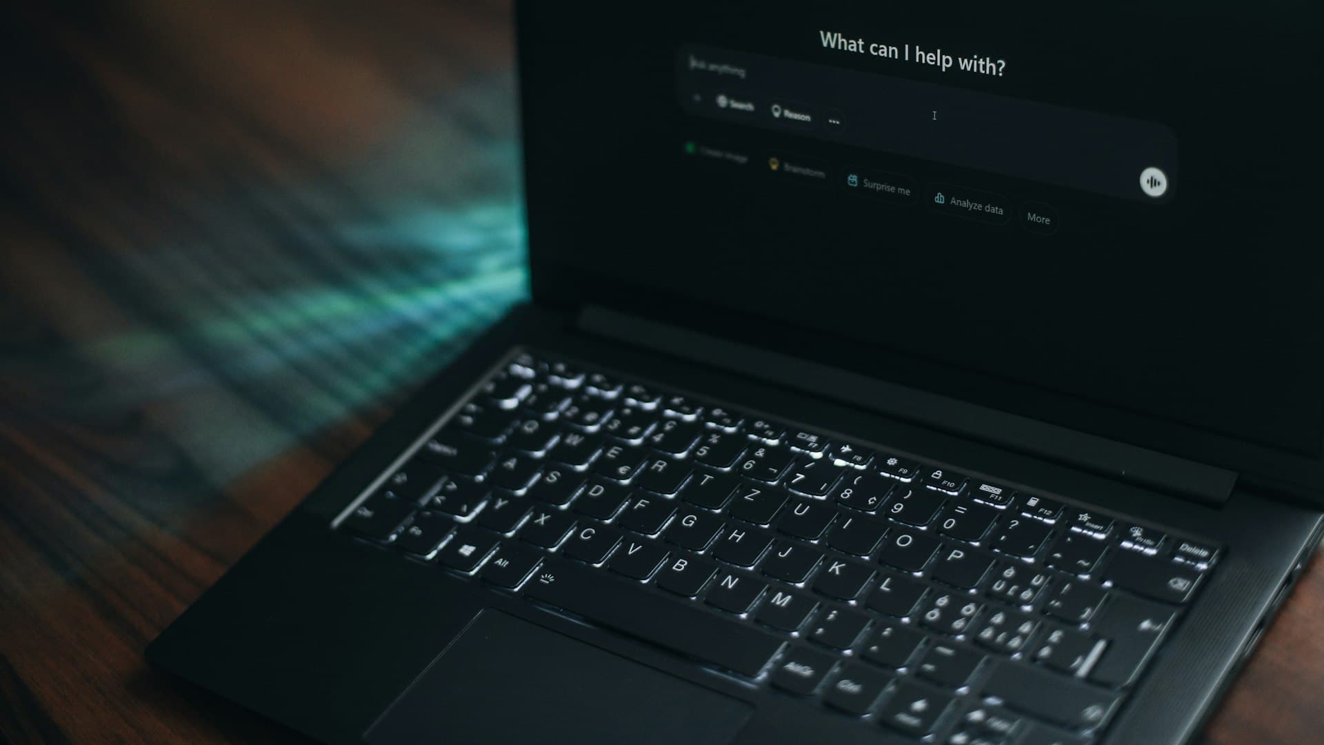 A laptop displaying a search bar asking how it can help